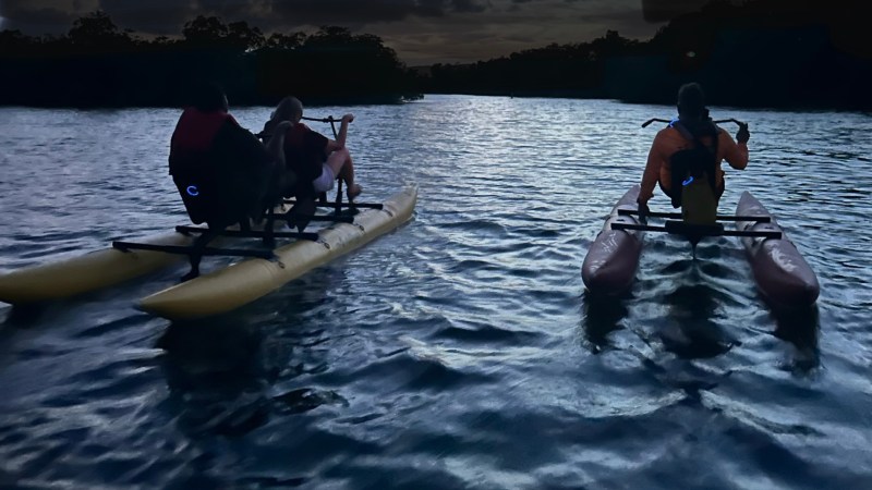 a man riding on the back of a boat in a body of water