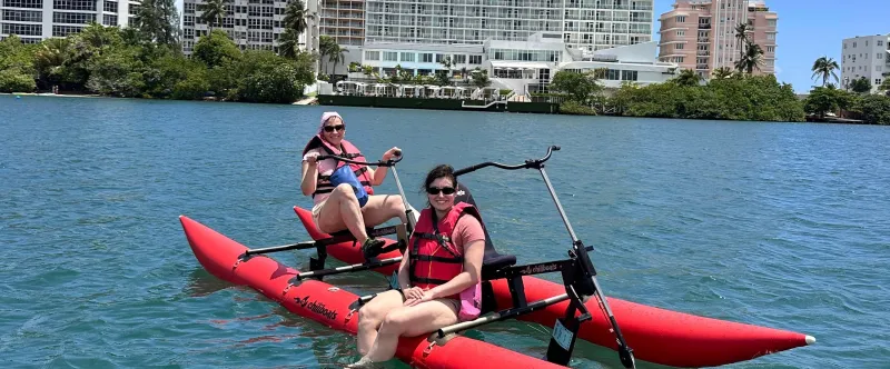 a group of people riding on the back of a boat in the water