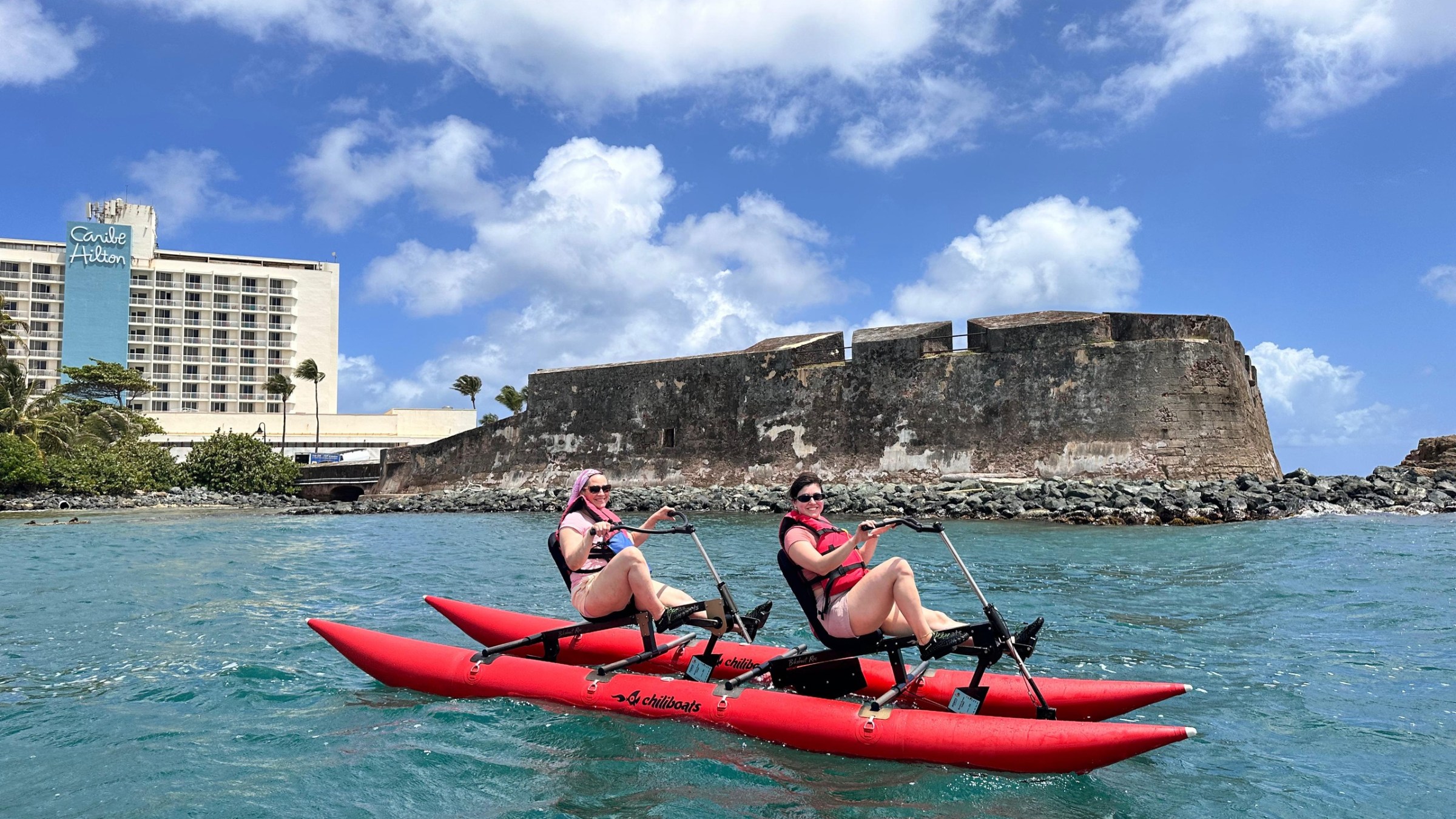a group of people riding on the back of a boat in the water