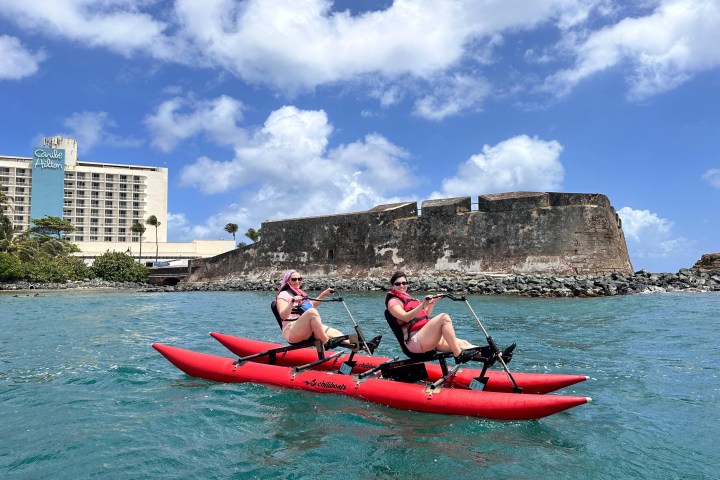 a group of people riding on the back of a boat in the water