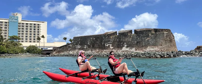 a group of people riding on the back of a boat in the water
