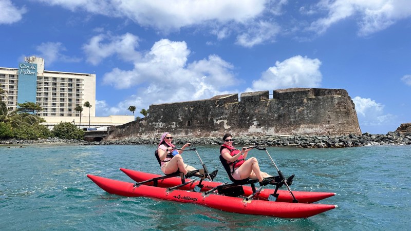 a group of people riding on the back of a boat in the water