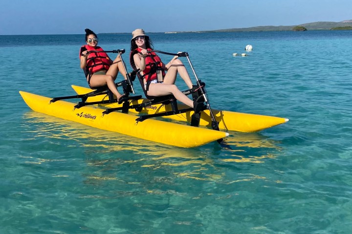 a group of people riding on the back of a boat in the water