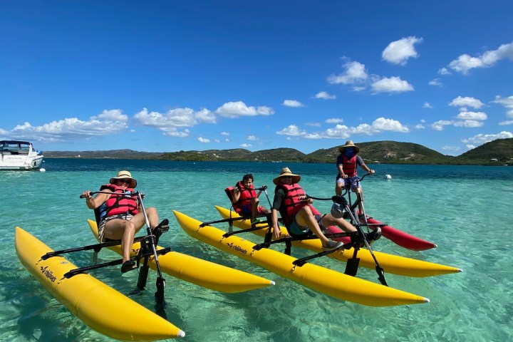 a group of people riding on the back of a boat in the water